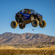 Blue UTV sails through the air in the California desert.